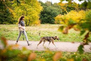 Tina Tschürtz mit Hund an lockerer Leine im Park